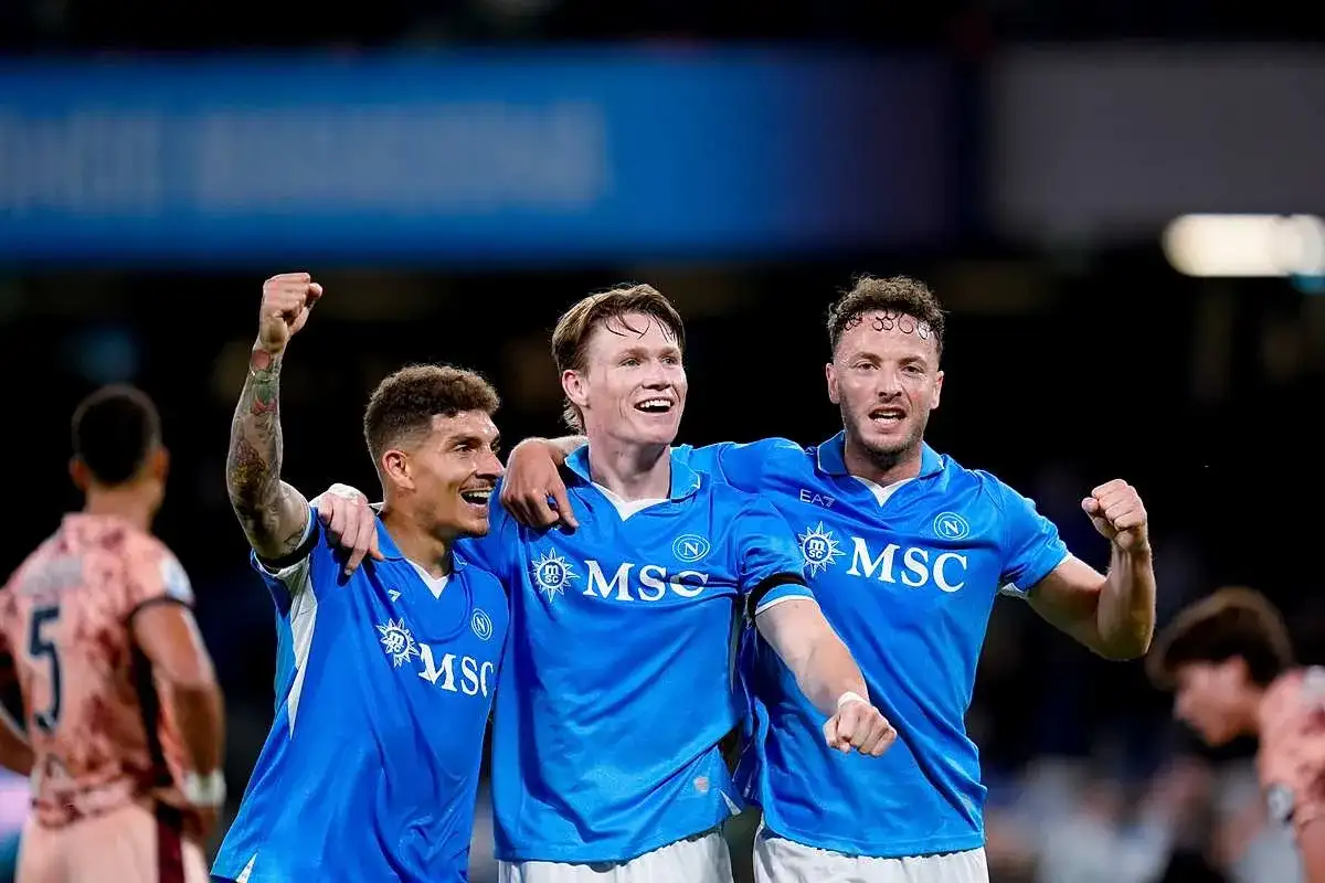 Piłkarze Napoli świętują zwycięstwo nad Hellas Verona. Radość na twarzach zawodników, jeden z nich unosi pięść w geście triumfu.