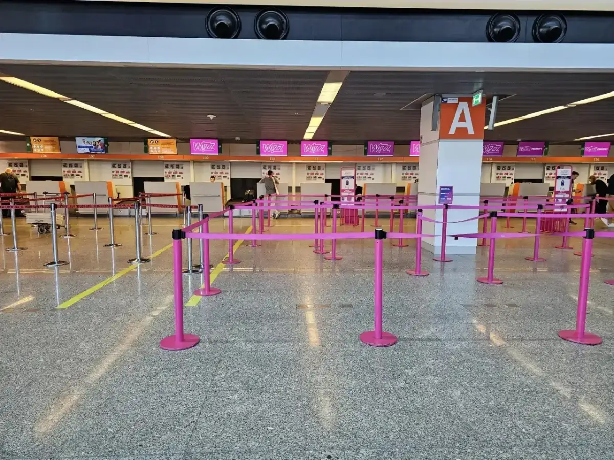 Puste stanowiska Wizzair, gdzie trwa odprawa. Różowe taśmy wyznaczają kolejkę do lotu.