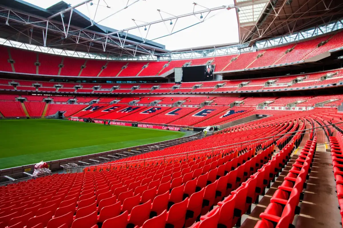 Puste czerwone trybuny jednego z największych stadionów w Anglii, Wembley, czekają na kibiców.