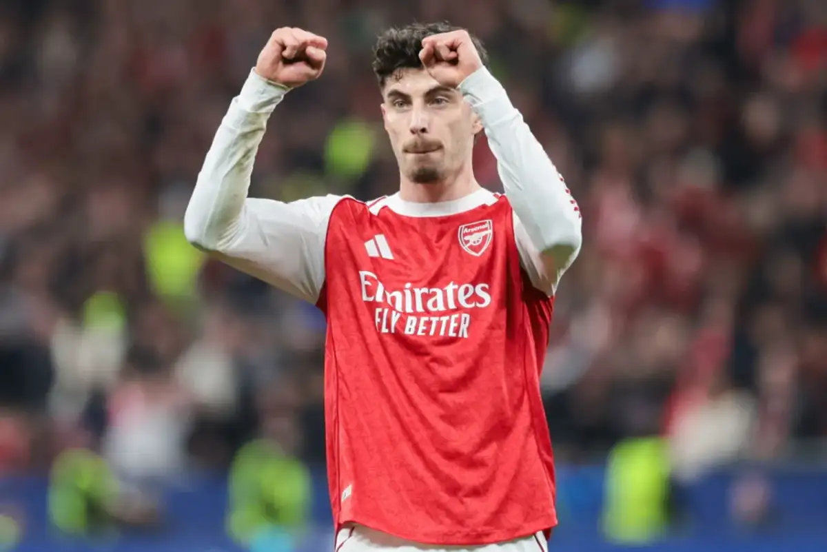 Piłkarz Arsenalu świętuje klasyczny hattrick, wznosząc pięści w geście triumfu na tle trybun.