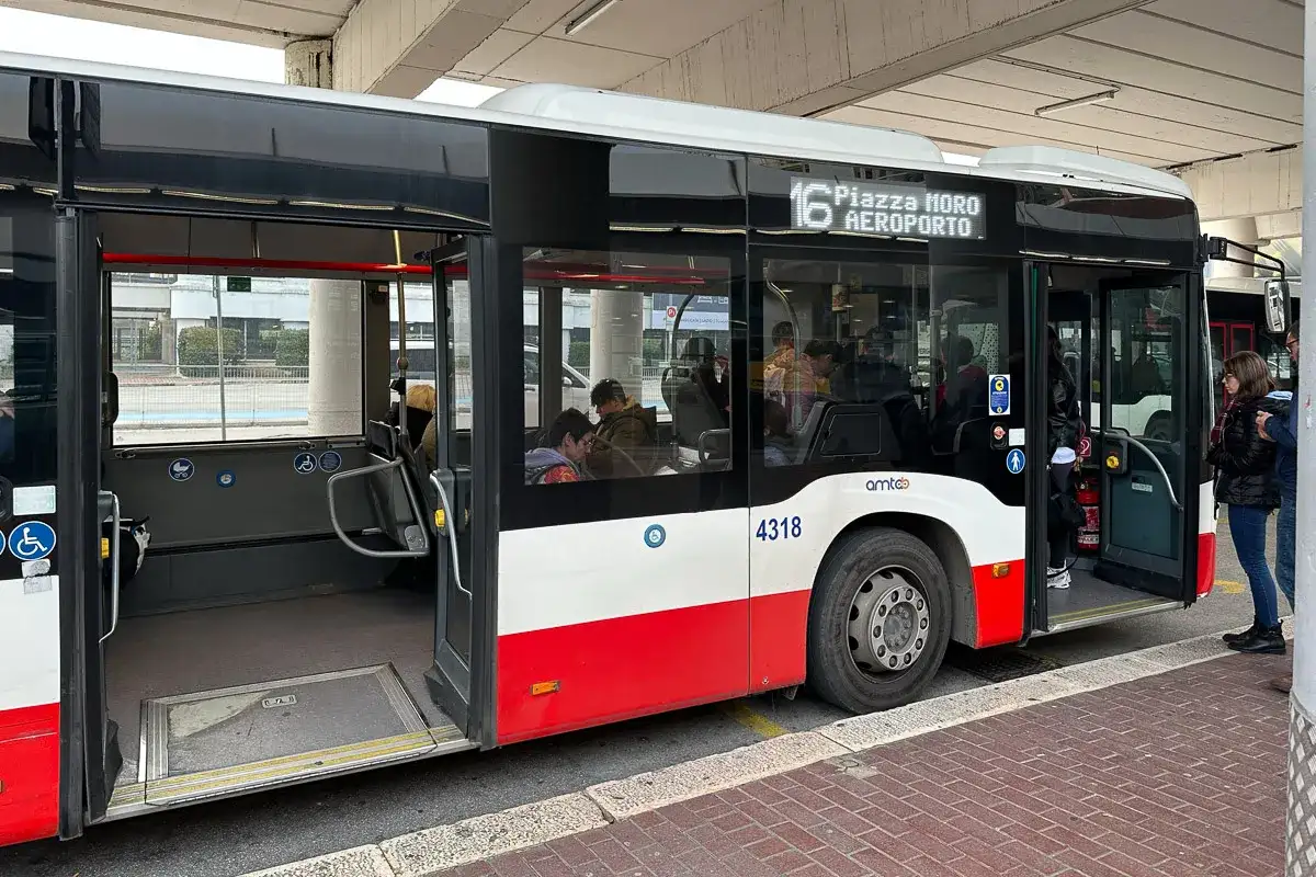 Autobus linii 16 do lotnisko w Bari czeka na pasażerów. W środku siedzą ludzie, drzwi są otwarte.