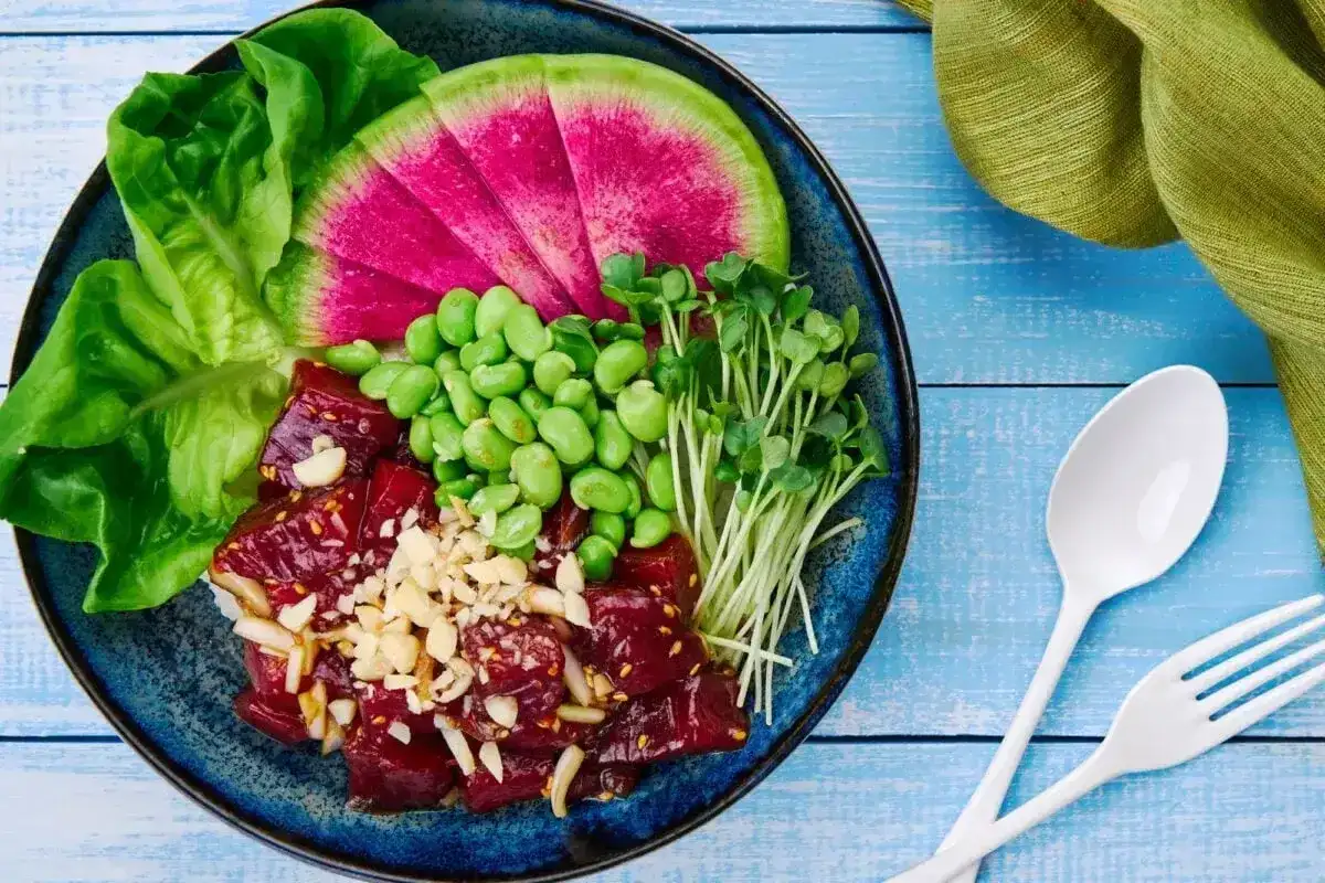 Kolorowy poke bowl: surowe ryby, edamame, rzodkiewka, kiełki i sałata. To właśnie jest poke bowl!
