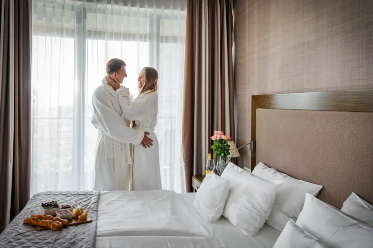 Para spędza romantyczny poranek w szlafrokach, delektując się śniadaniem. Idealny spa nad morzem dla dwojga.