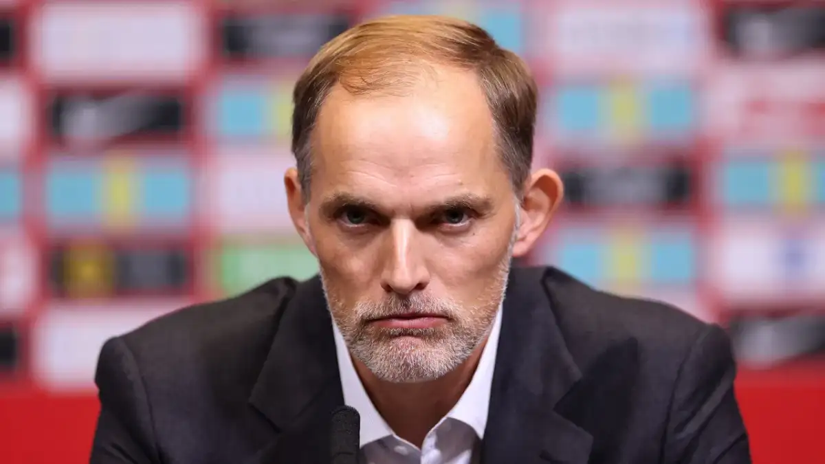 Thomas Tuchel, były trener Chelsea, z poważną miną przed mikrofonem.