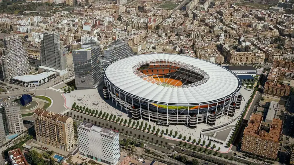 Nowoczesny walencja stadion otoczony miejską zabudową, z widocznym boiskiem i trybunami.