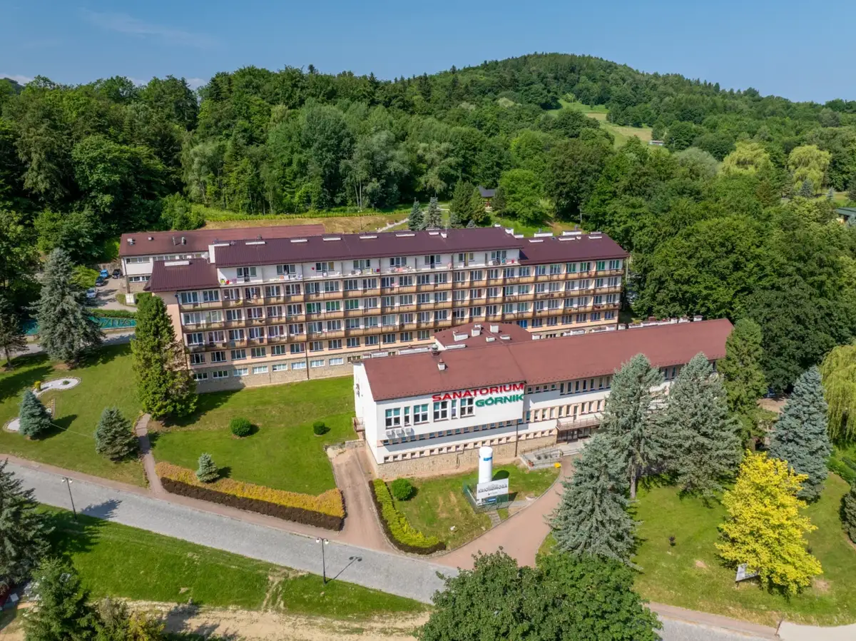 Sanatorium Górnik w Iwoniczu Zdroju, otoczone zielenią, zaprasza na wypoczynek.