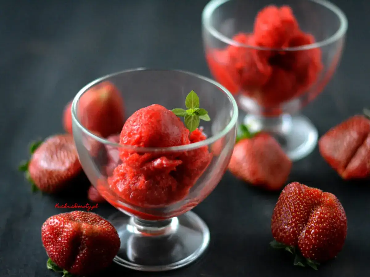 Jak zrobić sorbet truskawkowy? Pyszny, orzeźwiający deser w pucharkach, otoczony świeżymi truskawkami. Idealny na upalne dni.