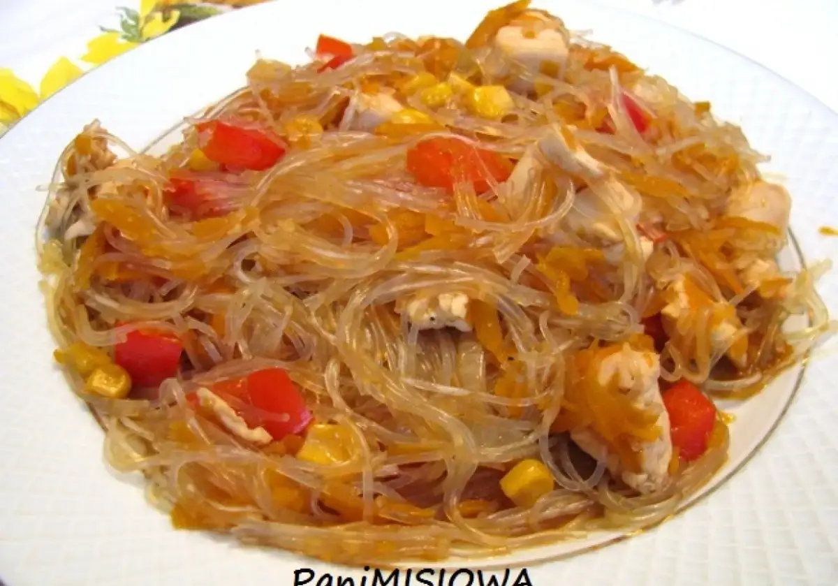 Pyszny makaron sojowy smażony z kurczakiem, papryką i kukurydzą. Danie wygląda apetycznie i kolorowo.