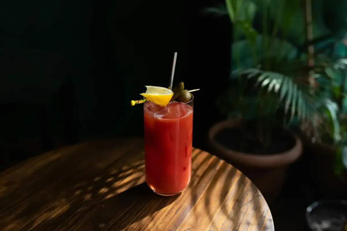 Kieliszek Bloody Mary z cytryną i oliwką. Ciekawa bloody mary historia tego drinka zaczyna się w latach 20. XX wieku.