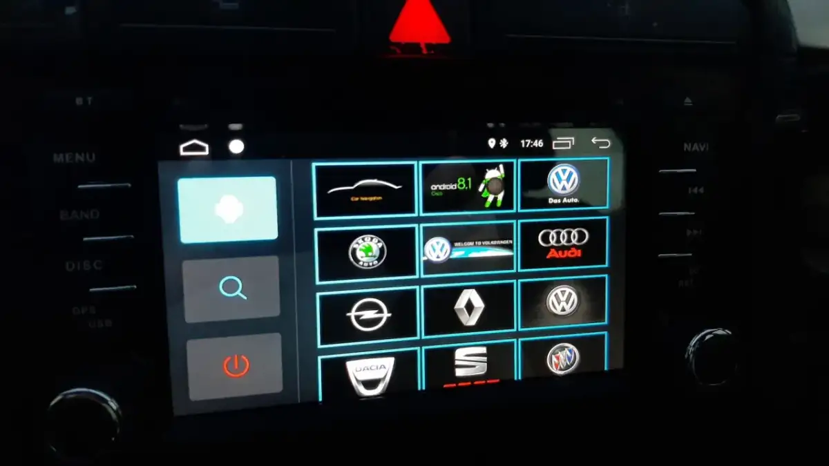 Ekran multimedialny z ikonami marek samochodów i opcją android auto ustawienia.
