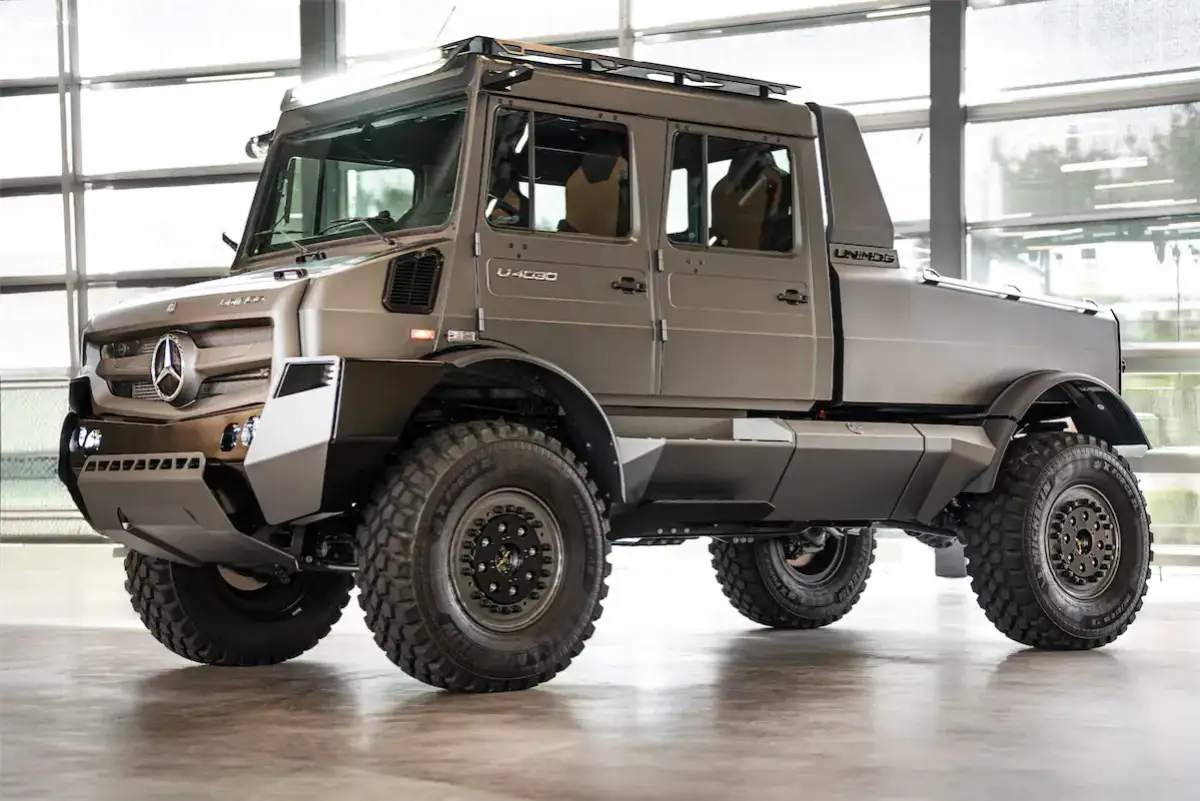 Szary, potężny Unimog U 4030 z podwójną kabiną i terenowymi oponami gotowy na każdą przygodę.