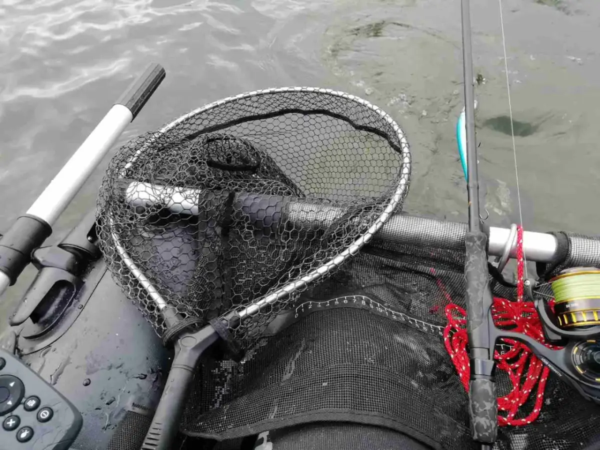 Łowienie na muchę z belly boat. Bezpieczne rzucanie sznurem z wody wymaga wprawy. Widoczny podbierak, wędka i kołowrotek.