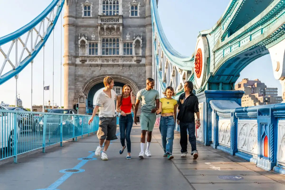 Grupa przyjaciół cieszy się londyńskim **city break** na Tower Bridge.