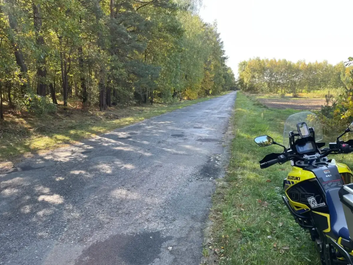 Żółty motocykl Suzuki zaparkowany przy leśnej drodze w Mazowieckiem.