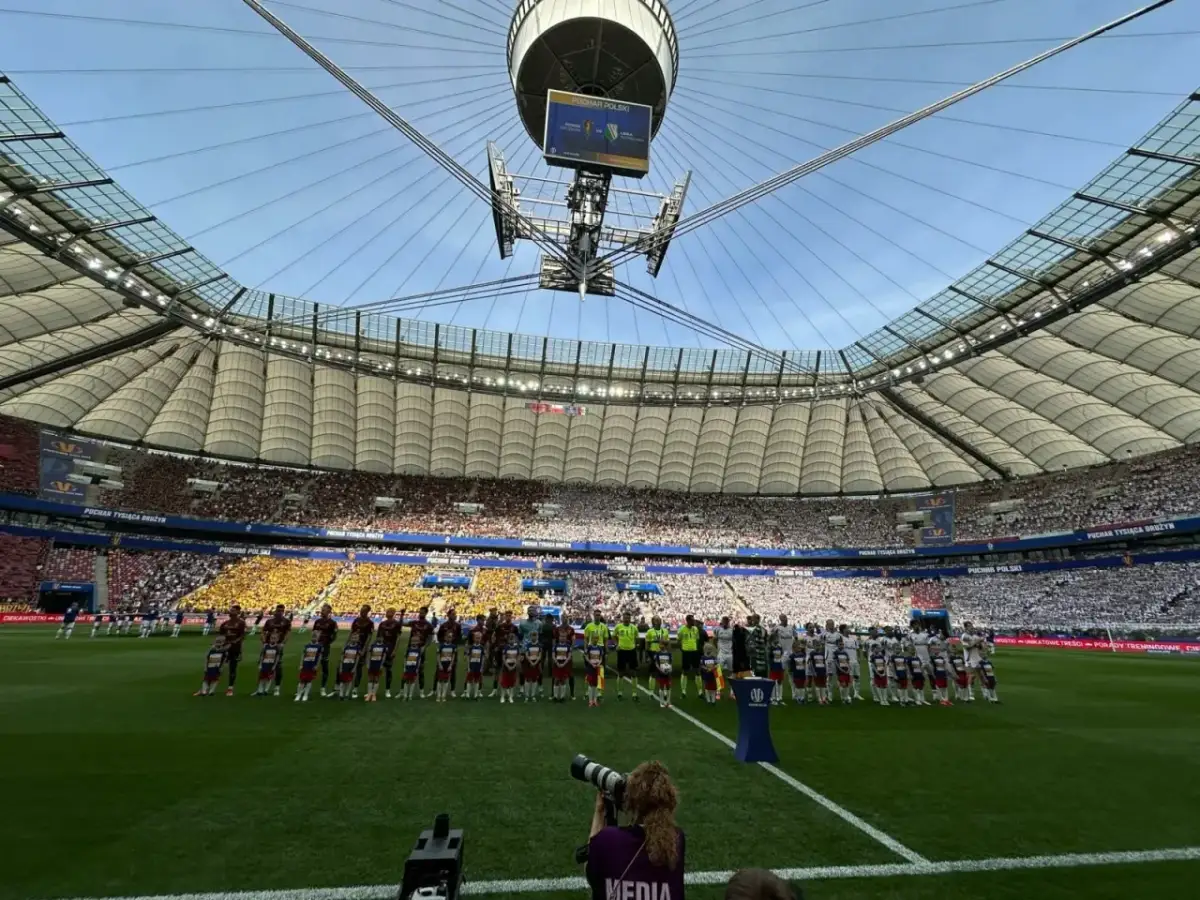 Piłkarze i dzieci stoją na murawie stadionu przed meczem Pucharu Polski.