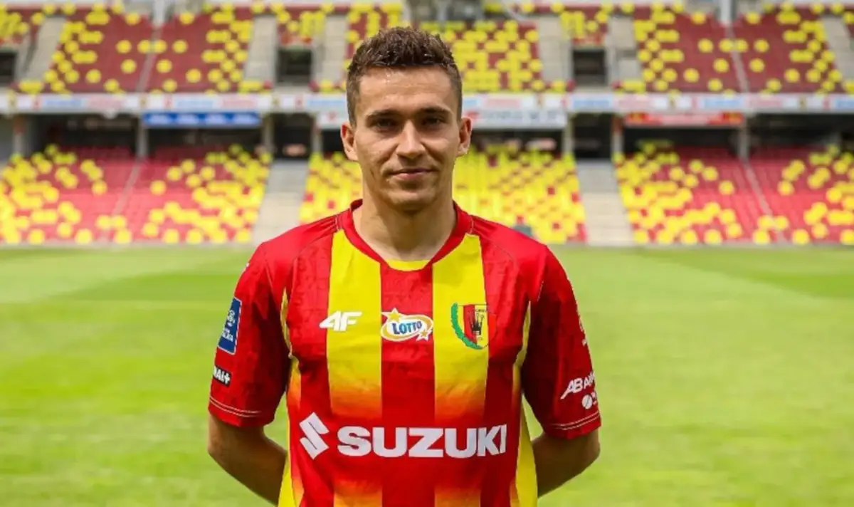 Piłkarz Korony Kielce w czerwono-żółtej koszulce na tle stadionu. Czekamy na kolejne transfery Korona Kielce!