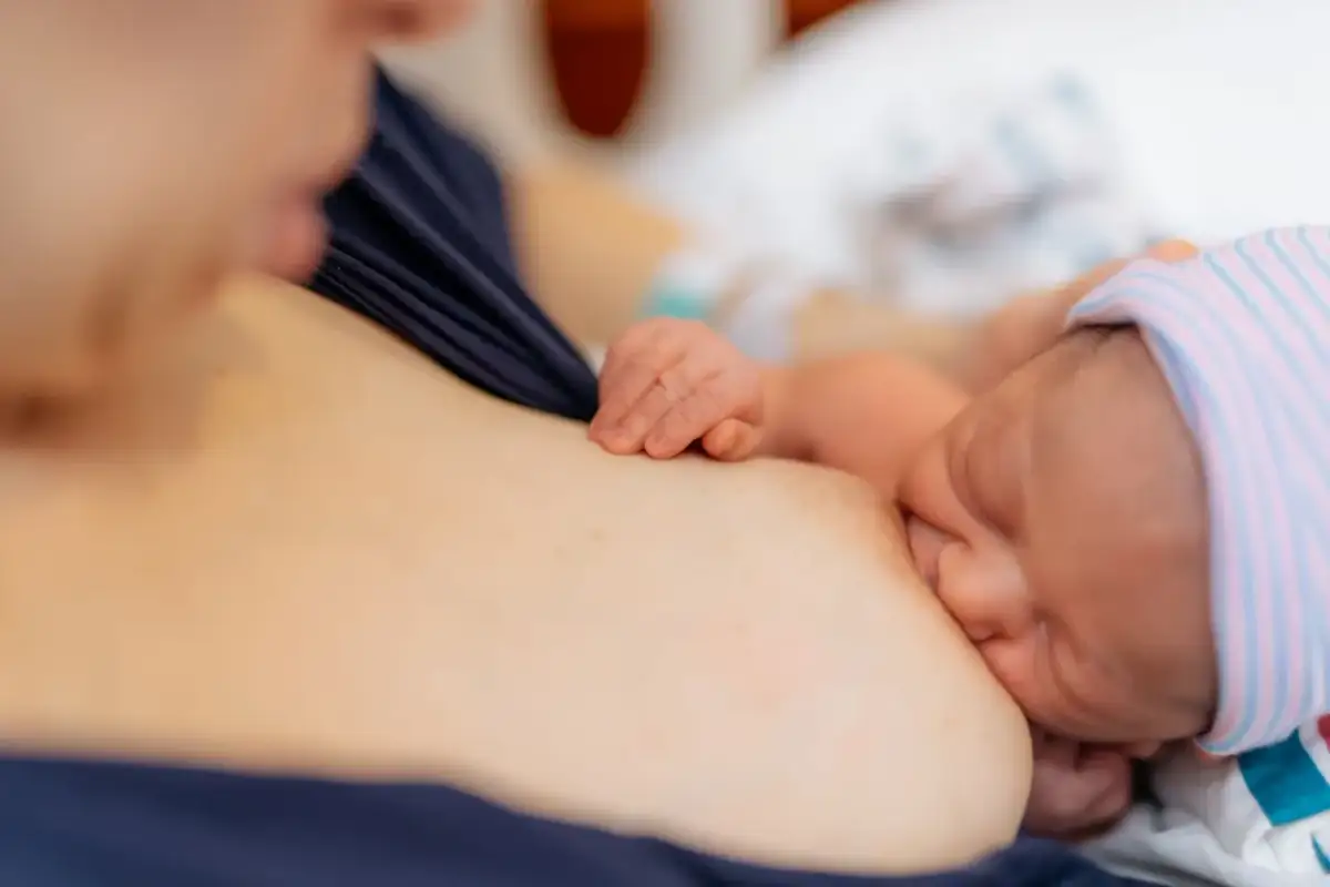 Nowa mama karmi piersią dziecko, co jest naturalne i bezpieczne, nawet po szczepieniu na COVID-19. Hafija.