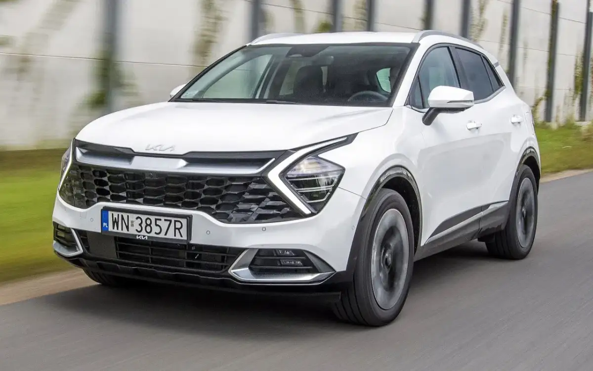 Biały Kia Sportage w ruchu. Wiele osób szuka kia sportage opinie, ten model wygląda obiecująco.