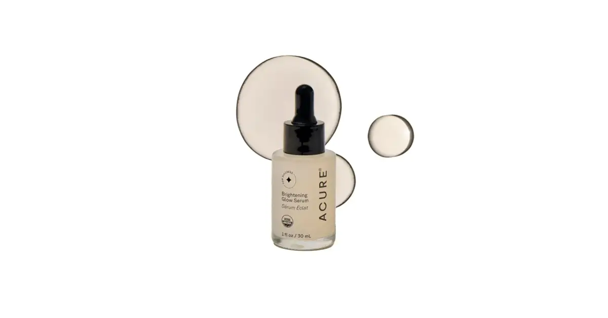 Szklana buteleczka z serum rozświetlającym ACURE z pipetką, na białym tle z kropelkami.