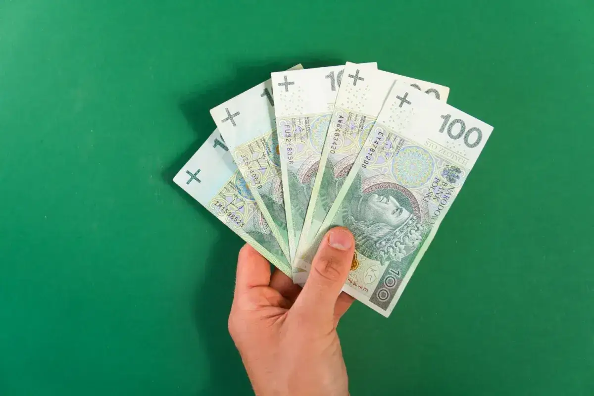 Dłoń trzyma banknoty 100 zł. Czy to już kwota wolna od podatku 2026?