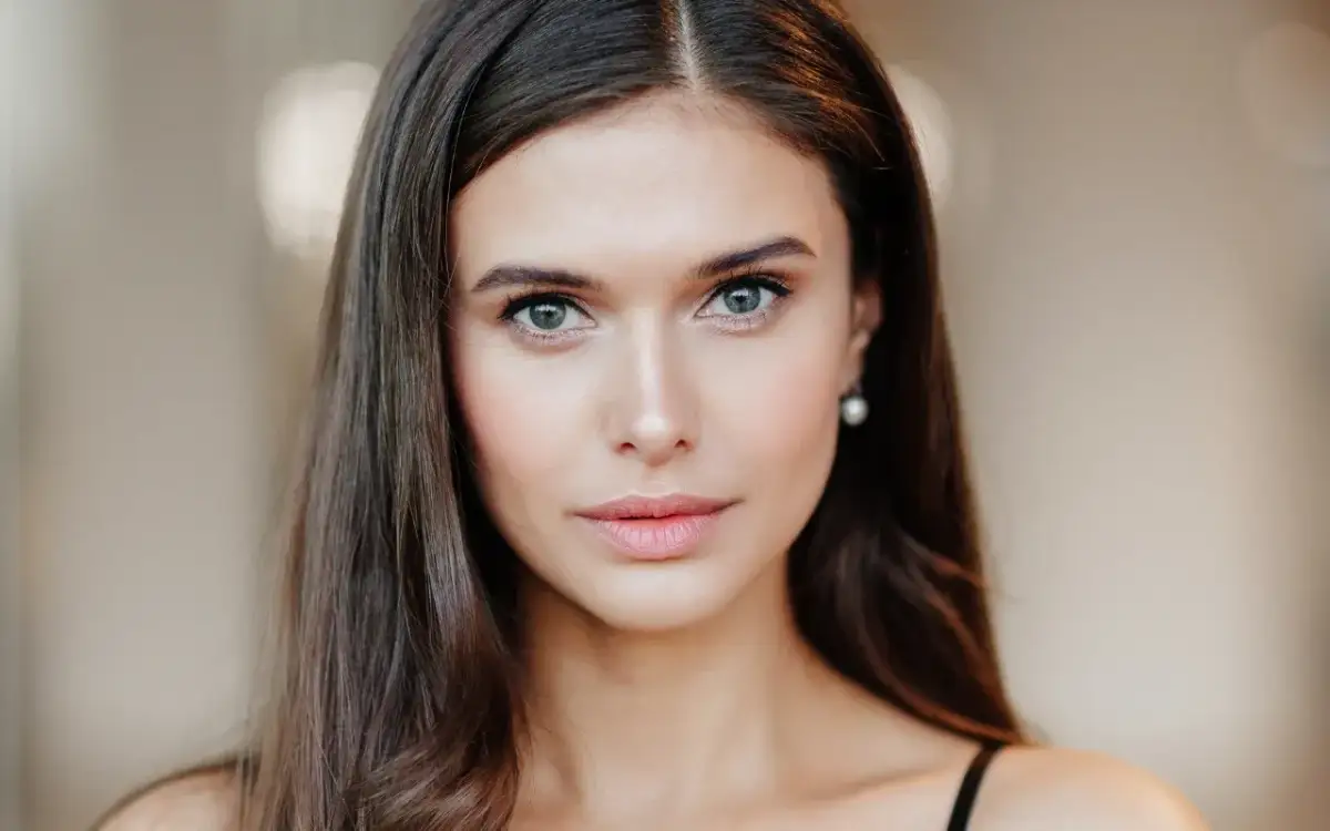 Portret młodej kobiety z naturalnym makijażem oczu i ust.