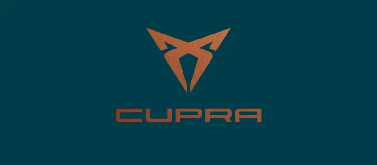 Miedziane logo Cupra na granatowym tle. Symbolizuje moc i dynamikę marki.