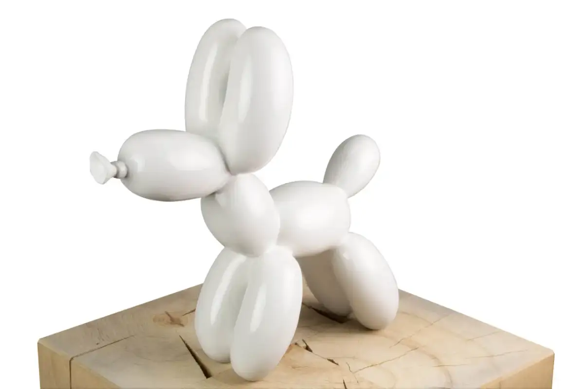 Weiße Ballonhunde-Skulptur auf Holzsockel.