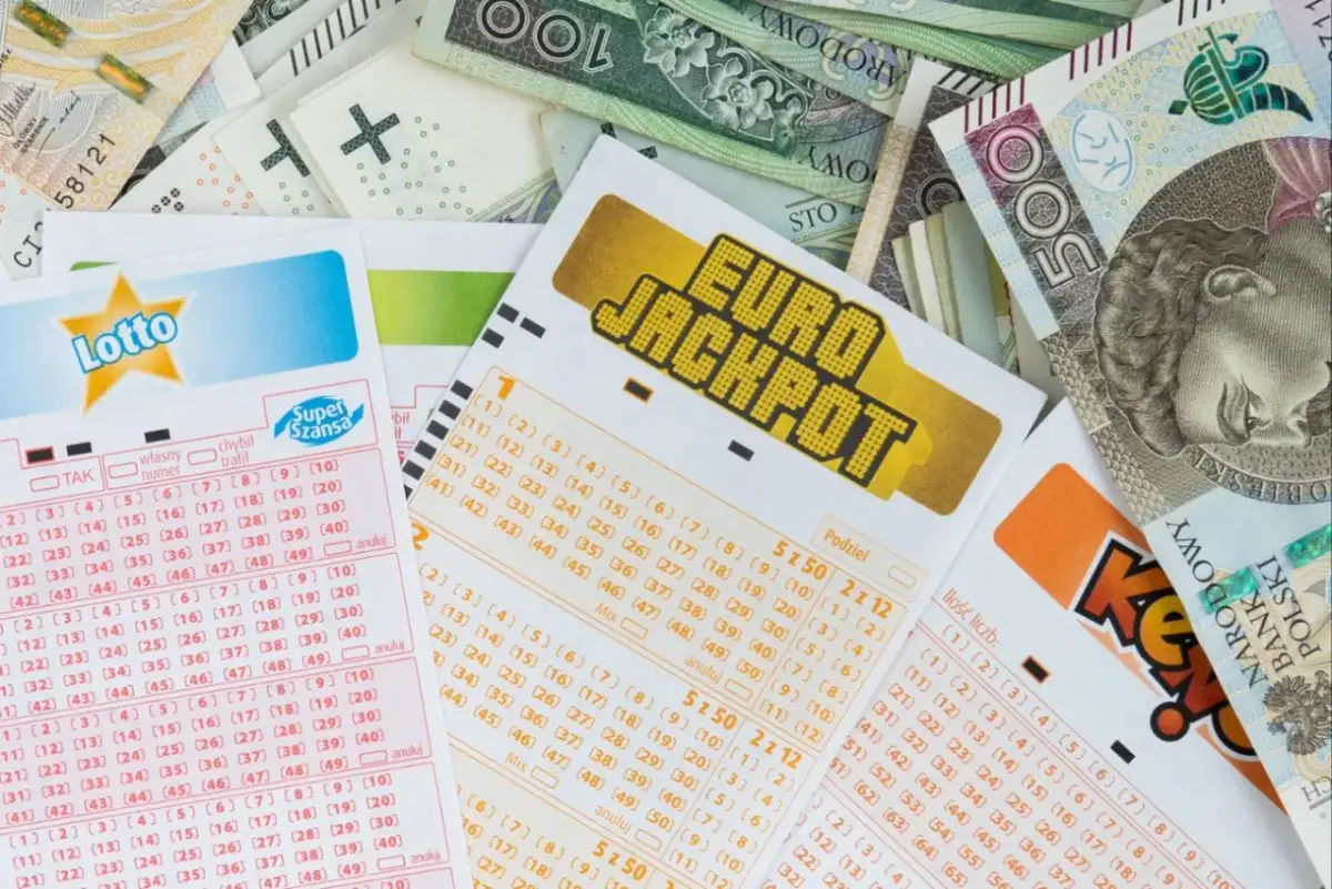 Kupony Lotto i Eurojackpot leżą na stosie banknotów. Zastanawiasz się, ile jest do wygrania w Eurojackpot dzisiaj?