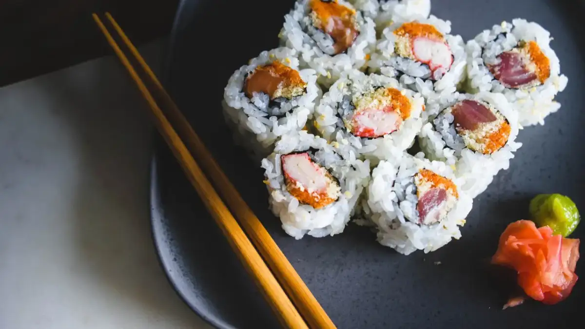 Talerz z sushi, pałeczki i dodatki. Zastanawiasz się nad sushi kcal? Smacznego!