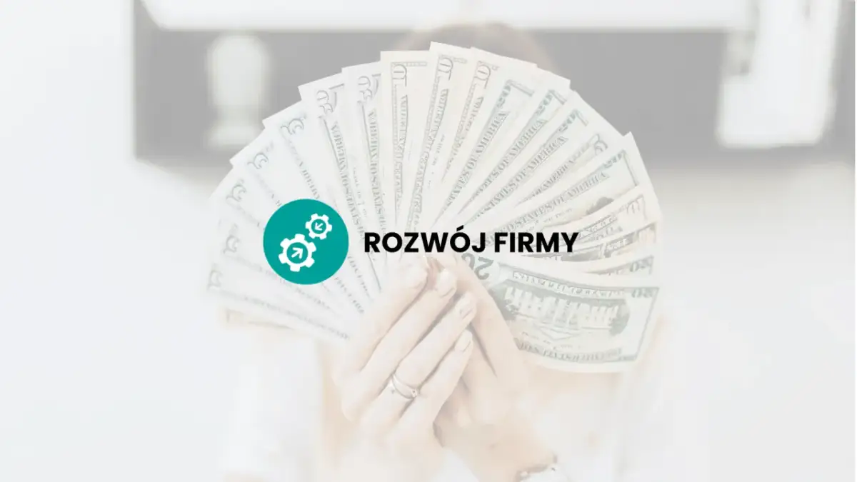 Dłoń trzyma wachlarz banknotów dolarowych z ikoną i napisem "ROZWÓJ FIRMY".