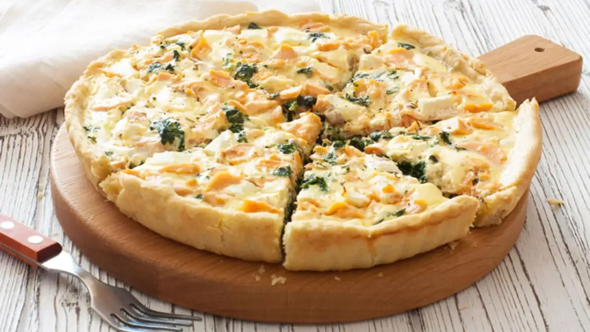 Tarta de espinacas y salmón, recién horneada y cortada en porciones, lista para disfrutar.