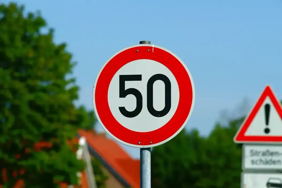 Znak ograniczenia prędkości do 50 km/h. Jaka prędkość w terenie zabudowanym jest dozwolona? Ten znak informuje kierowców.