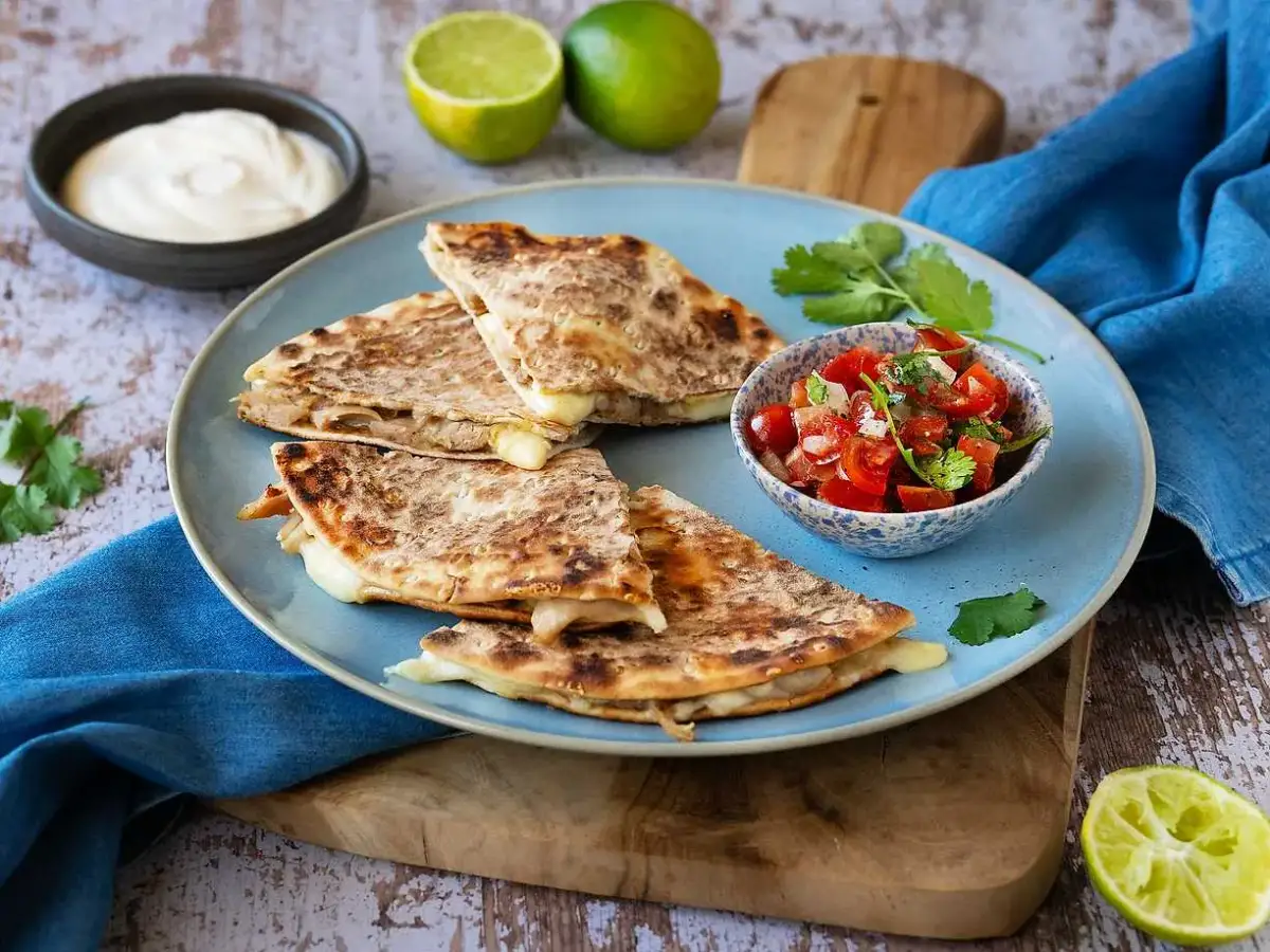 Här är ett läckert quesadillas recept! Krispiga quesadillas med smält ost, serverade med salsa, gräddfil och lime.