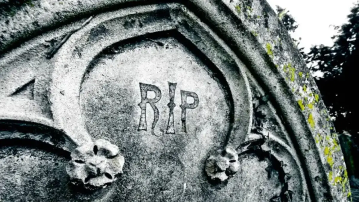 Napis "RIP" na kamiennym pomniku, co oznacza "Requiescat in pace" (Niech spoczywa w pokoju), symbolizuje wieczny odpoczynek.