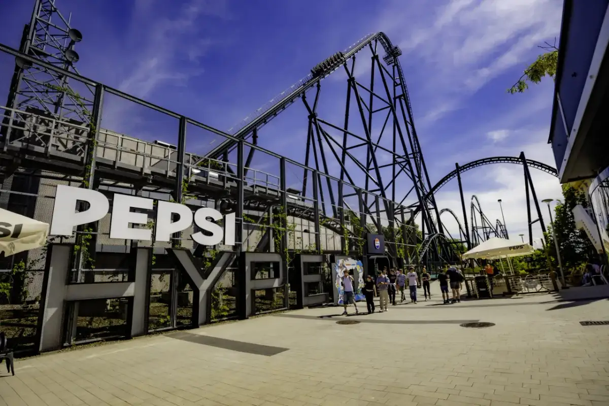Duża konstrukcja z napisem "PEPSI HYPERION" i kolejką górską w tle.