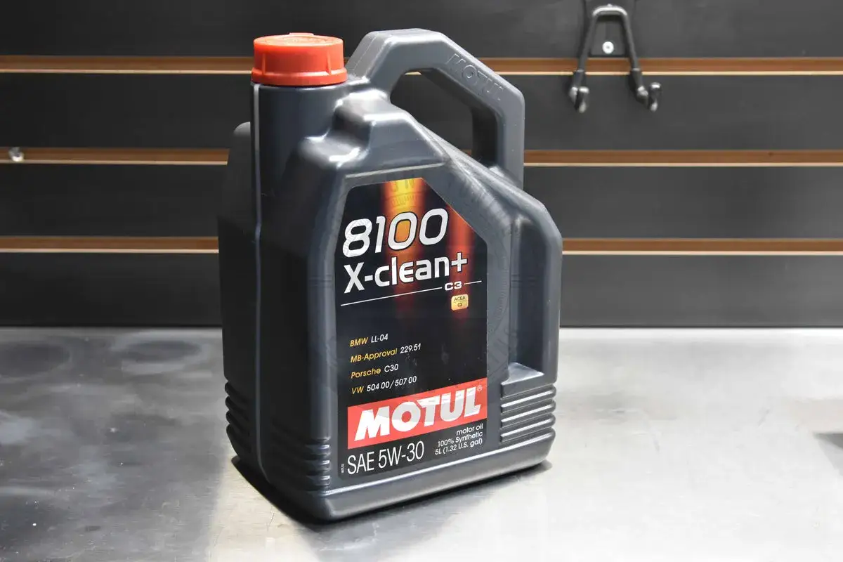 Czarna bańka oleju silnikowego Motul 8100 X-clean+ 5W-30 z czerwonym korkiem.