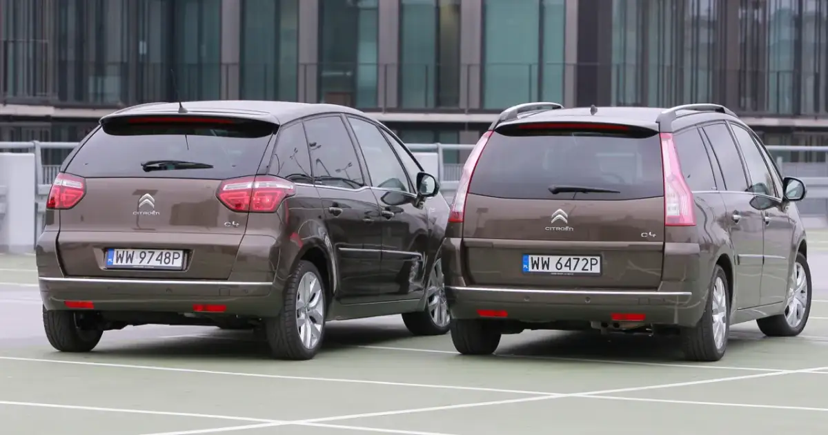 Dwa brązowe Citroen Grand Picasso stoją obok siebie na parkingu.