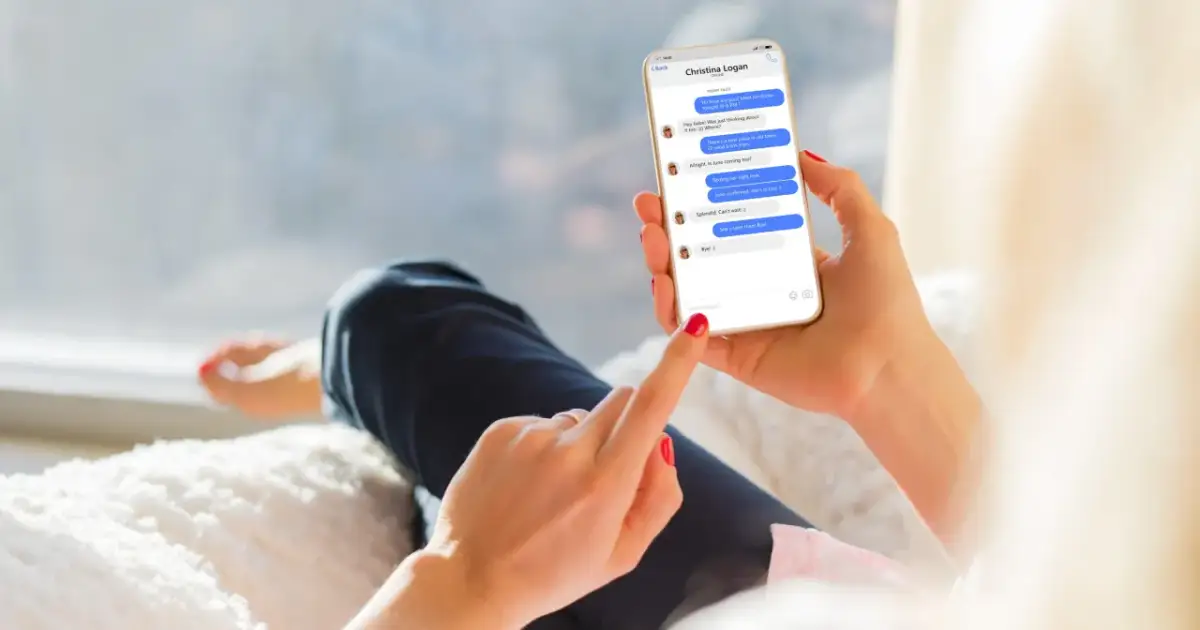 Dłoń trzyma smartfon z rozmową na Messengerze. Można tu zobaczyć, jak być niewidocznym na Messengerze, ale widzieć innych, gdy ekran pokazuje status "online" u rozmówcy.