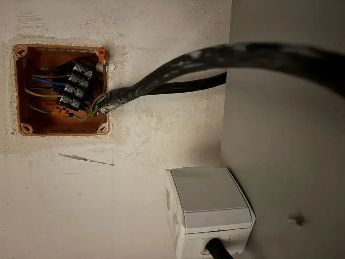 Instalacja elektryczna: jak podłączyć piekarnik bez wtyczki. Widoczne przewody w puszce instalacyjnej i gniazdko.