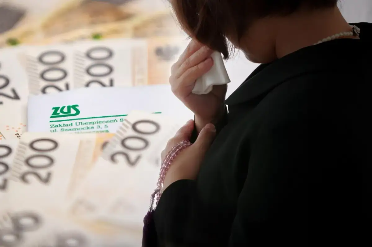 Kobieta ociera łzy chusteczką na tle banknotów 200 zł i dokumentu ZUS.