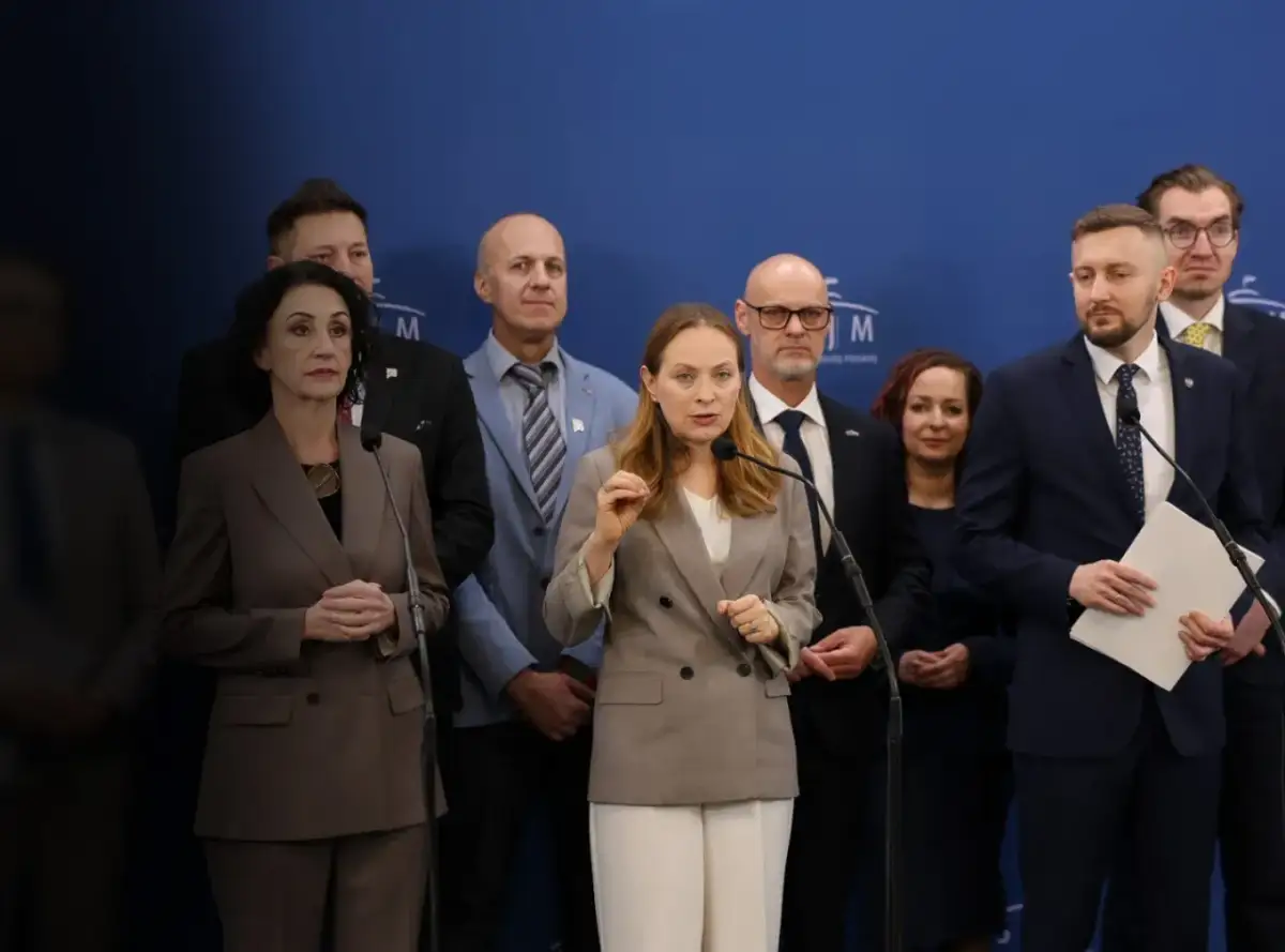Grupa osób na tle niebieskiej ściany. Kobieta przemawia do mikrofonu, gestykulując. W tle inni mężczyźni i kobiety. Czym Polska 2050 różni się historycznie od nowoczesnej?