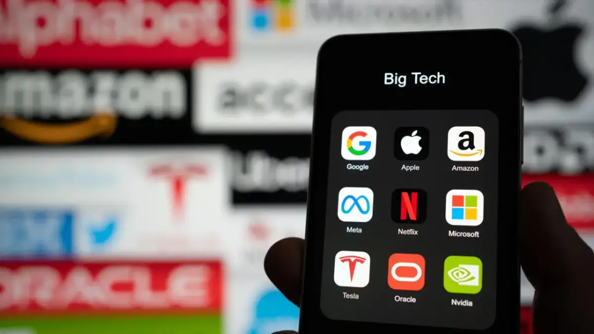 Ikona "Big Tech" na telefonie, z logotypami Google, Apple, Amazon, Meta, Netflix, Microsoft, Tesla, Oracle, Nvidia. Dyskusja o podatek cyfrowy.