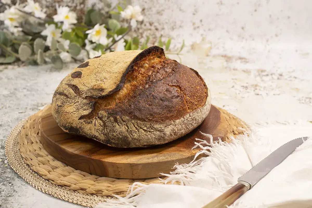 Pan artesanal de masa madre, dorado y crujiente, listo para disfrutar. El arte de hacer pan con masa madre.