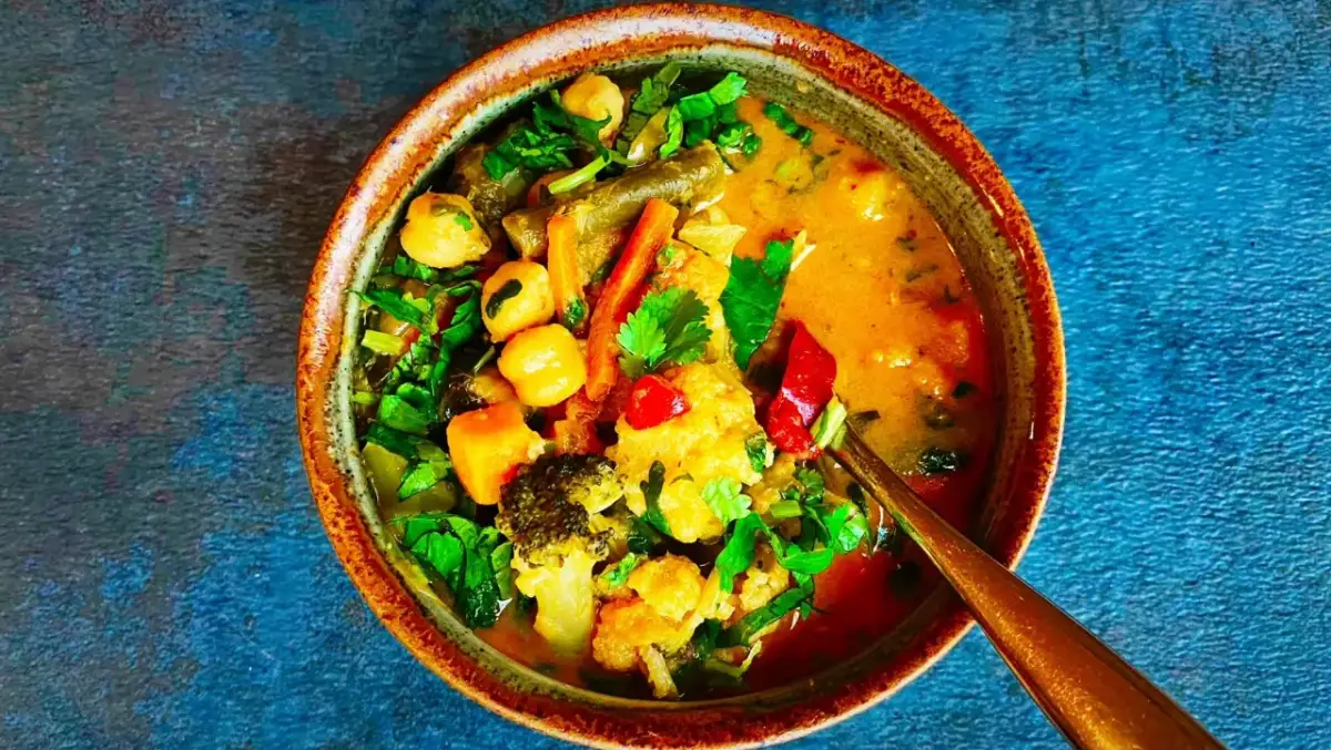 Miseczka tajskiego curry z warzywami, ciecierzycą i mlekiem kokosowym.