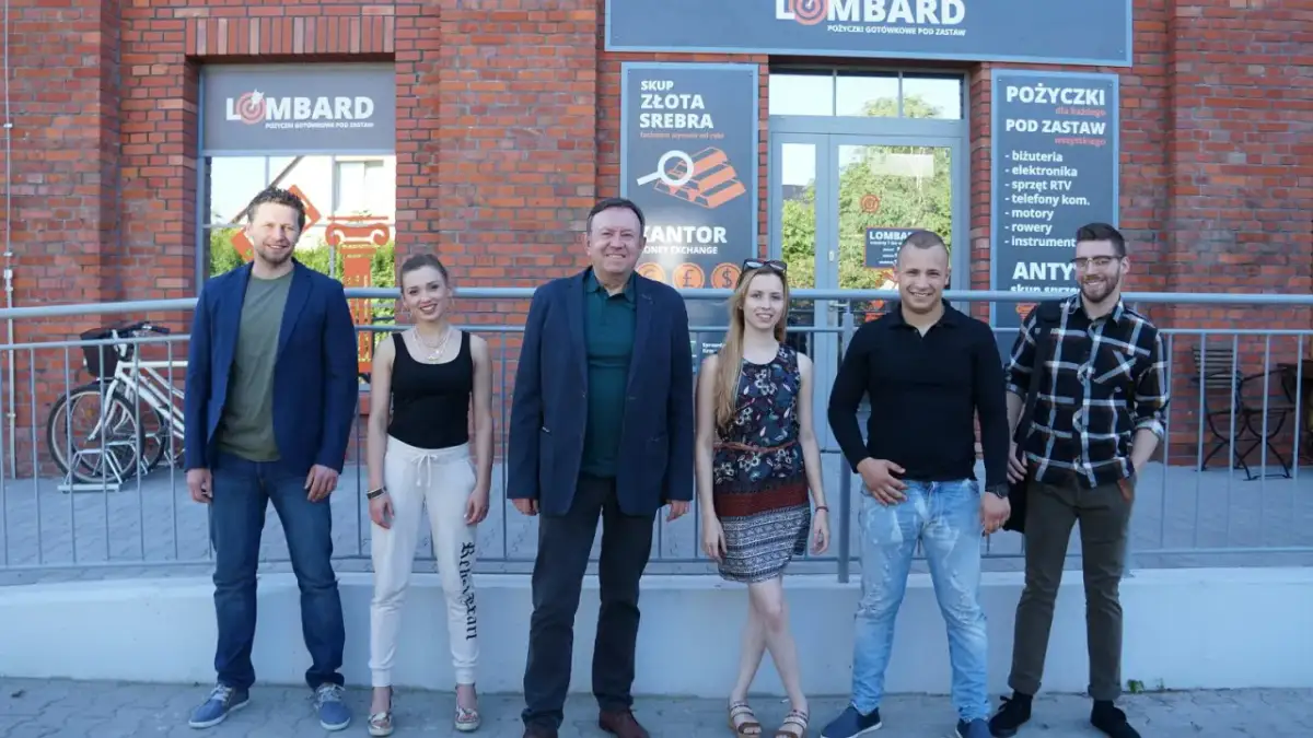 Ekipa lombardu "Życie pod zastaw" pozuje przed budynkiem.