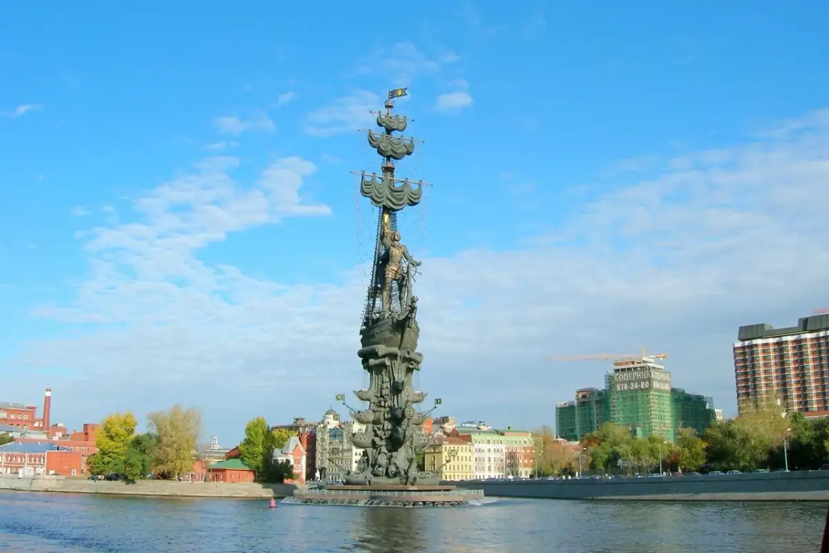 Majestatyczny pomnik Piotra Wielkiego na statku, górujący nad rzeką i panoramą miasta.