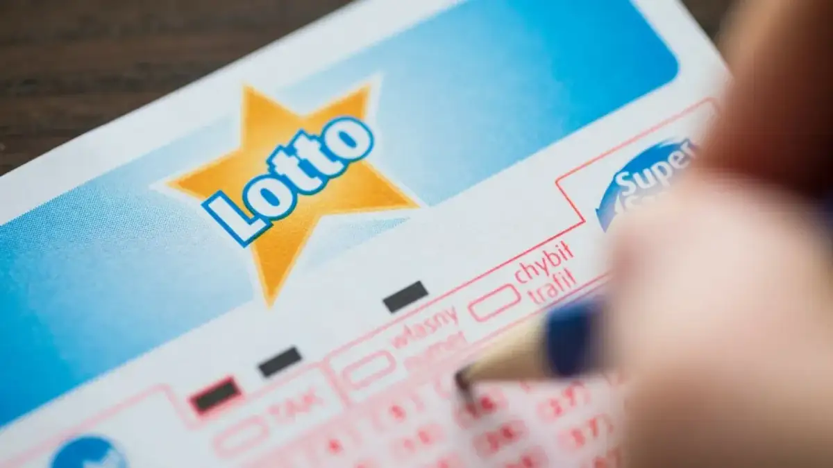 Kupon Lotto, ręka z ołówkiem. Dziedziczenie nagrody w loterii jak prawo traktuje kupony w spadku.