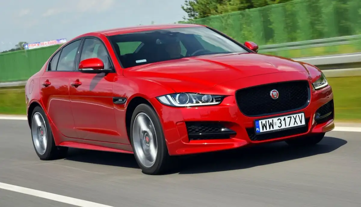 Czerwony Jaguar XE w ruchu na drodze.