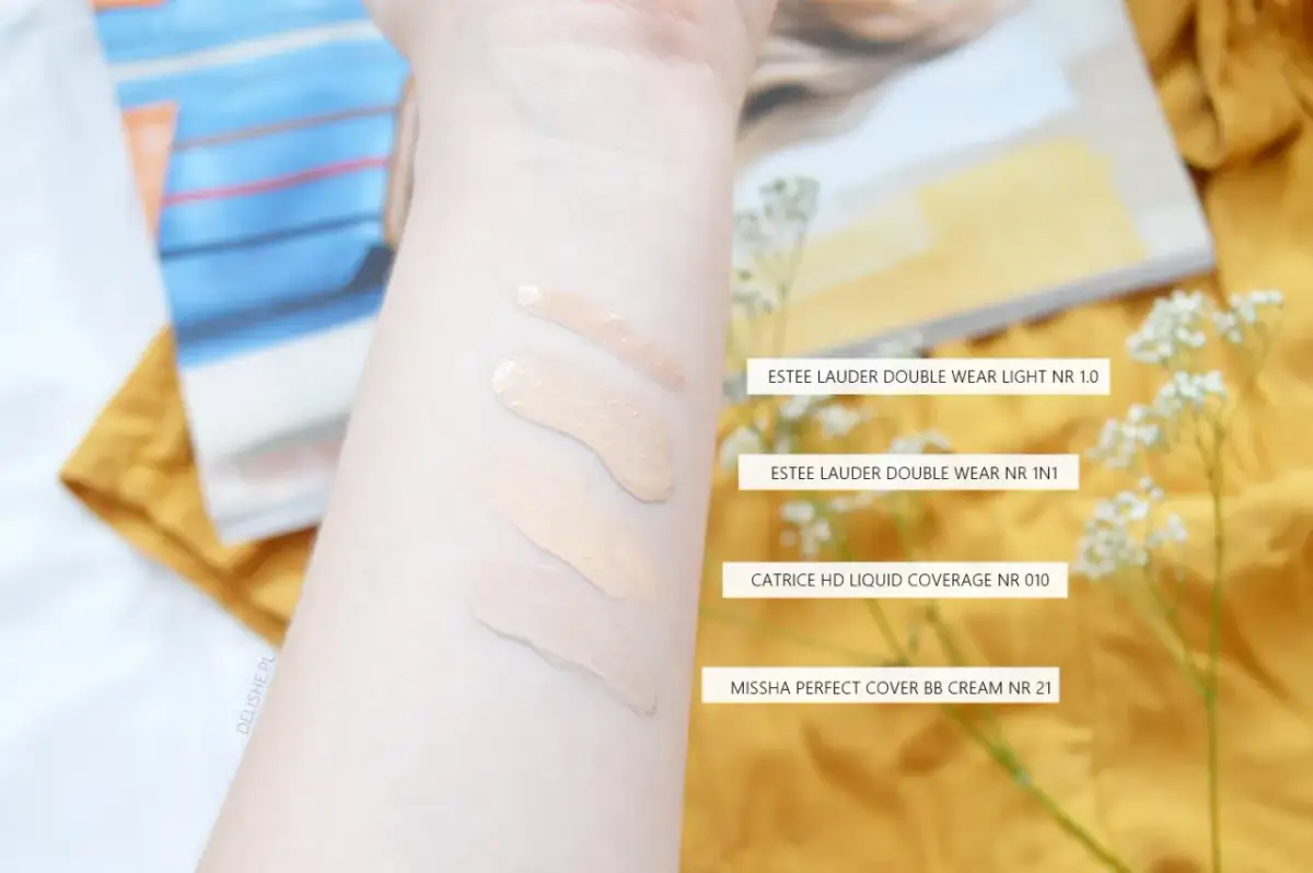 Smugi podkładów na przedramieniu: Estee Lauder, Catrice i Missha.