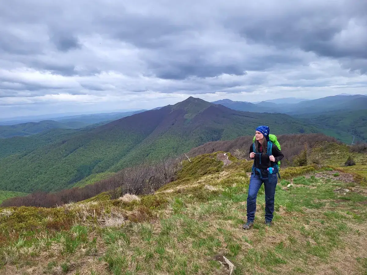 Kobieta z plecakiem na tle górskiego krajobrazu, szlak czerwony beskidzki.